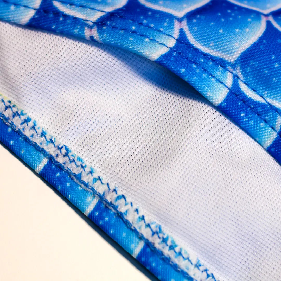 Zoomed view Studio product photography of Inner detail double layer Bikini bottom featuring a blue fish scales print, part of the Ocean Queens Delphi, Happy, Swim Brief collection