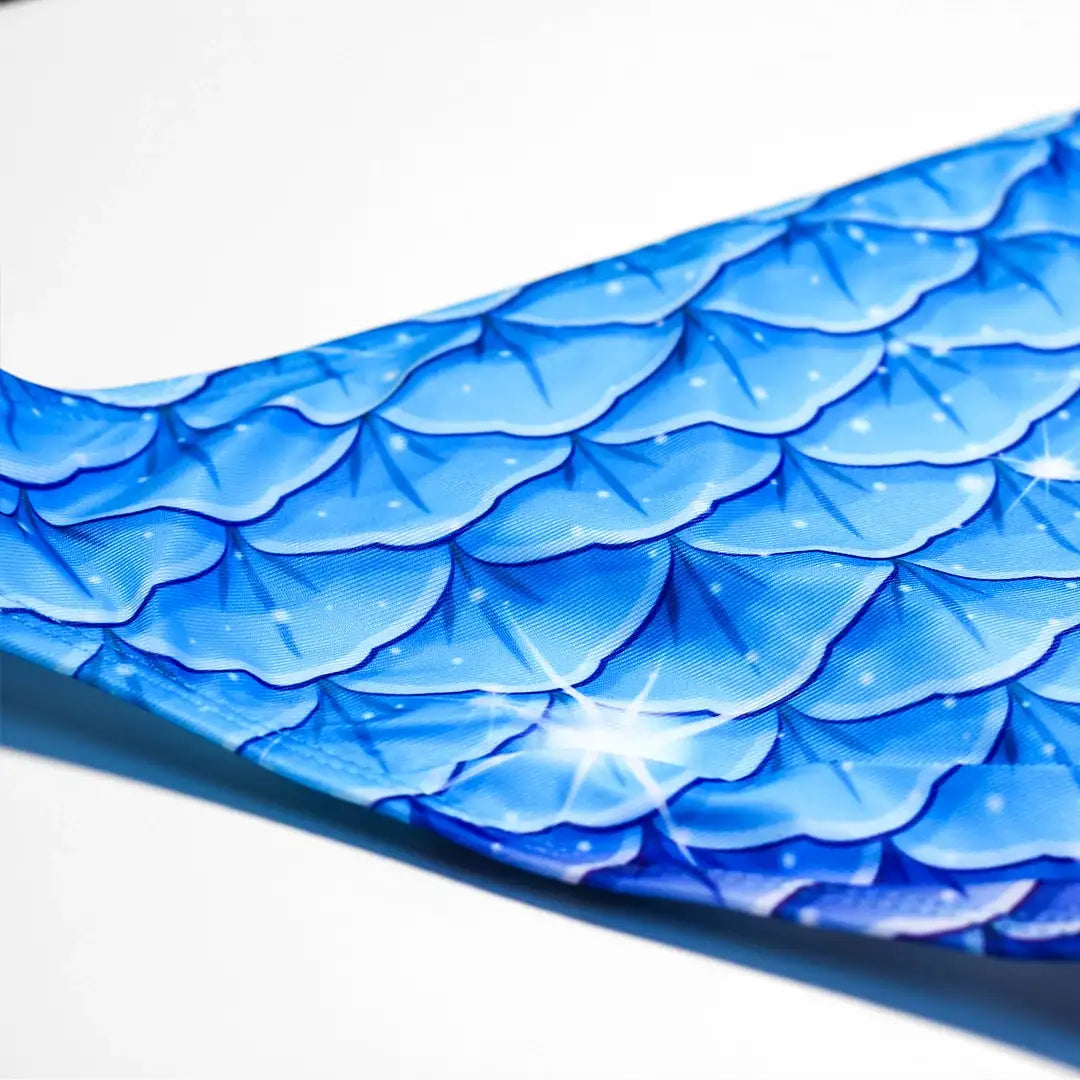 Detail view Studio product photography of back Bikini bottom featuring a blue fish scales print, part of the Ocean Queens Galaxy Swim Brief collection