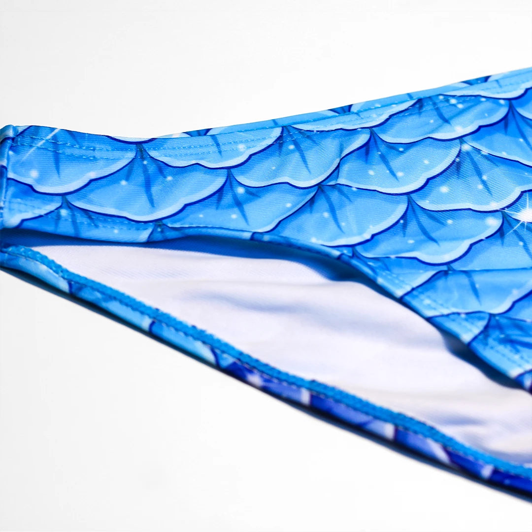Front Detail view Studio product photography of Bikini bottom featuring a blue fish scales print, part of the Ocean Queens Galaxy Swim Brief collection