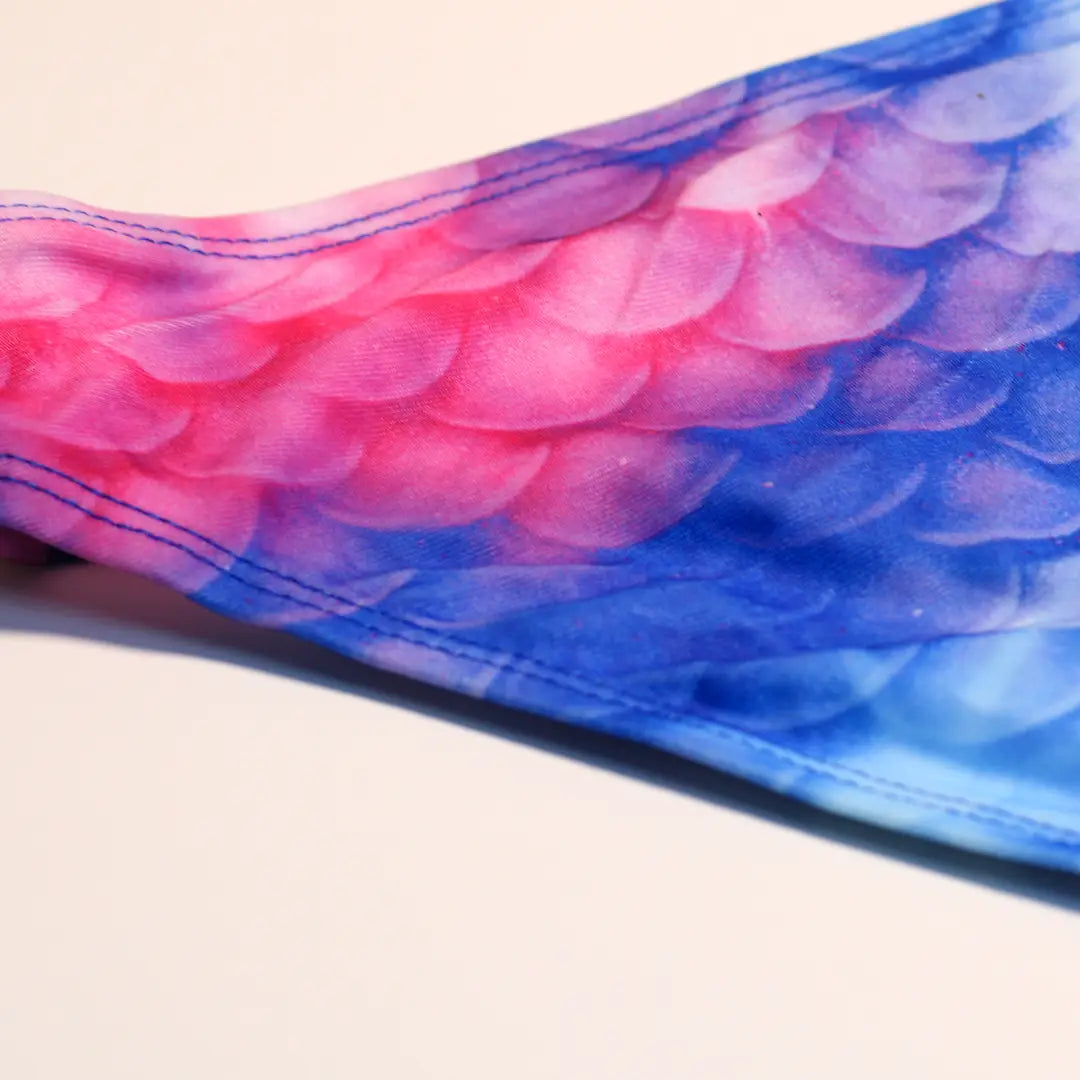 Detail back view Studio product photography of Bikini bottom featuring a blue and pink galaxy fish scales print, part of the Ocean Queens Lunar Swim Brief collection