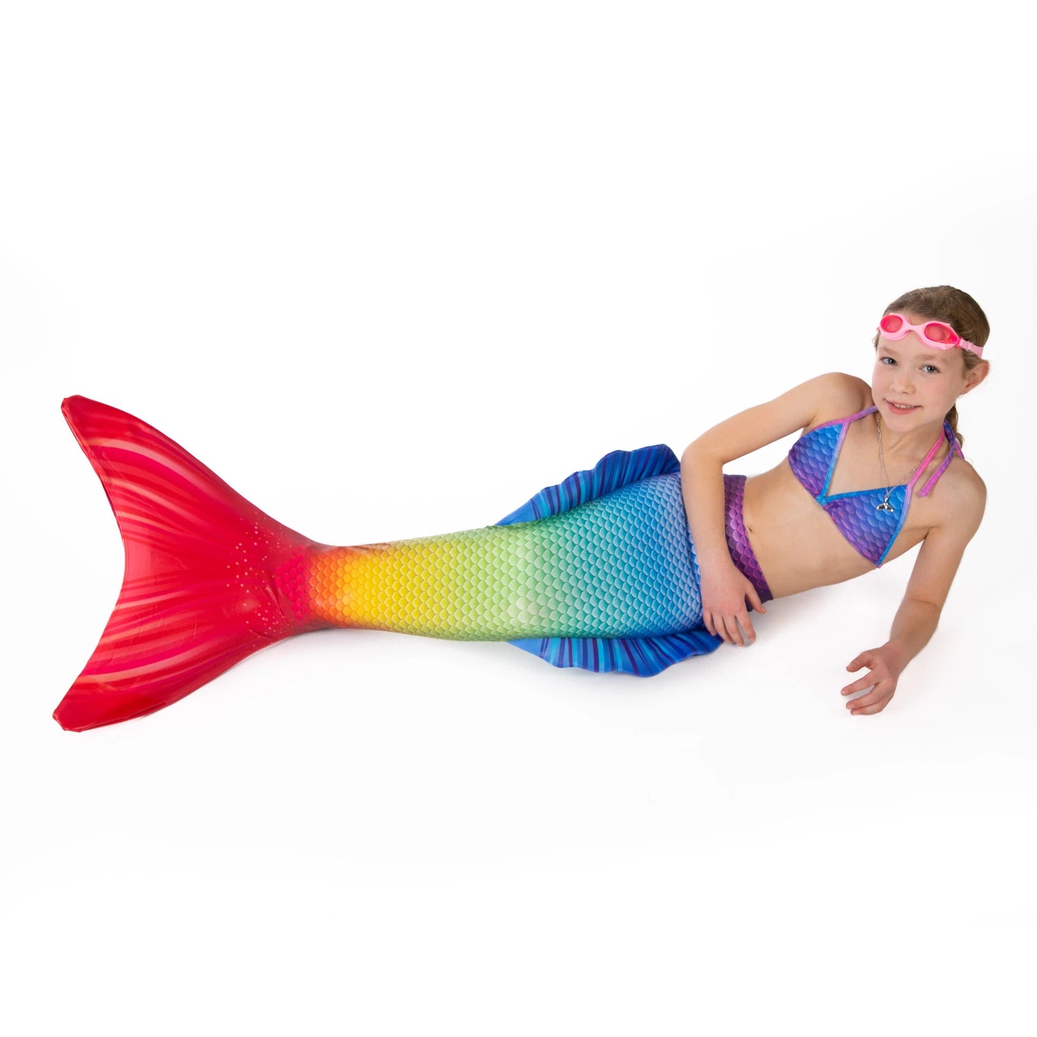 Girl with Ocean Queens Happy mermaid tail set on. Pink swimming goggles on head| studio photography